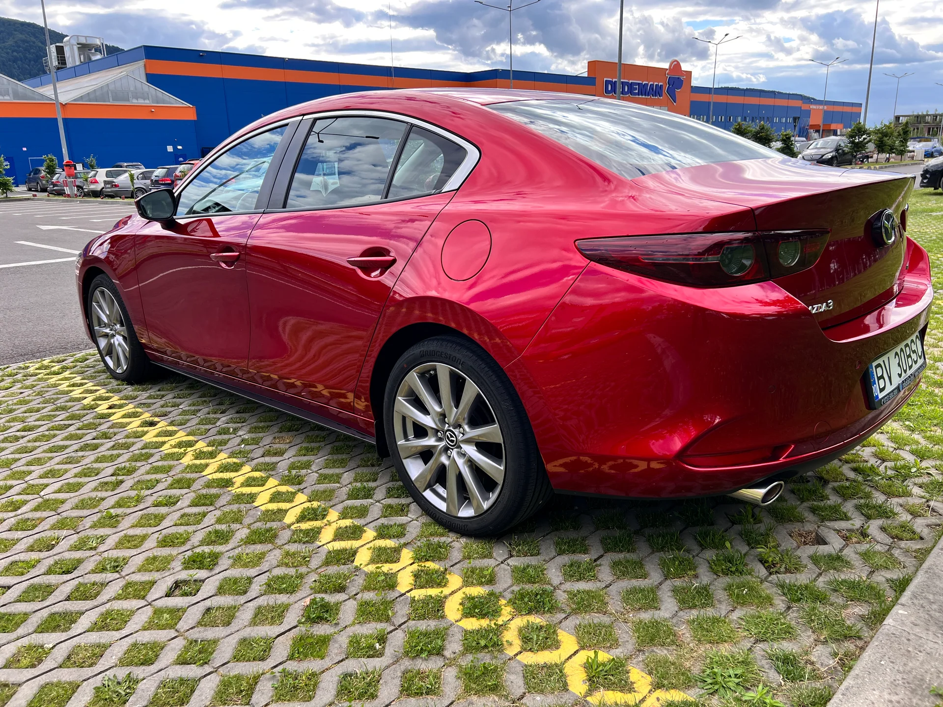 Mazda 3 roșie, vedere spate trei sferturi